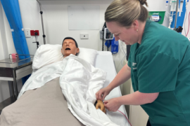 Louise practicing administration of therapy on a dummy in a sim lab