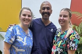 Three Registered Nurse Graduates stand in a courtyard.