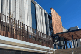 The facade of a hospital building showing stairs leading up to the forecourt and terrace.